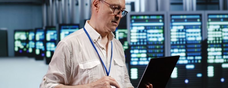 Focused IT support executive in data storage company equipped to handle complex computational operations, doing checking on server devices, verifying efficiency parameters to prevent liabilities